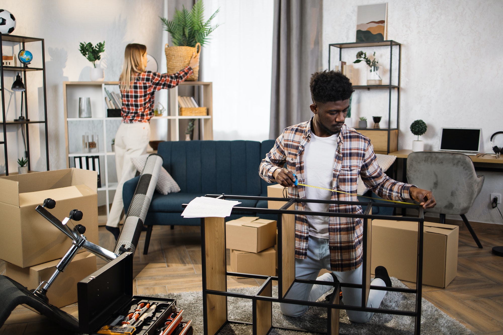 Diverse young family improving interior at new flat